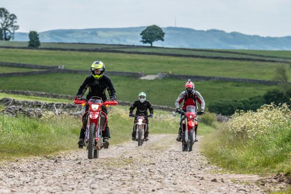 Three trail bikes on a green lane