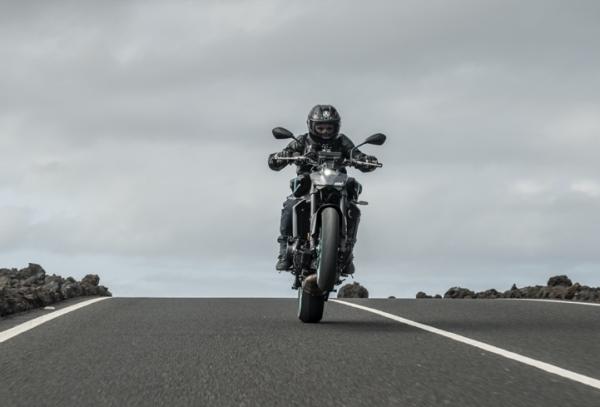 A motorcycle pulling a wheelie on a closed road