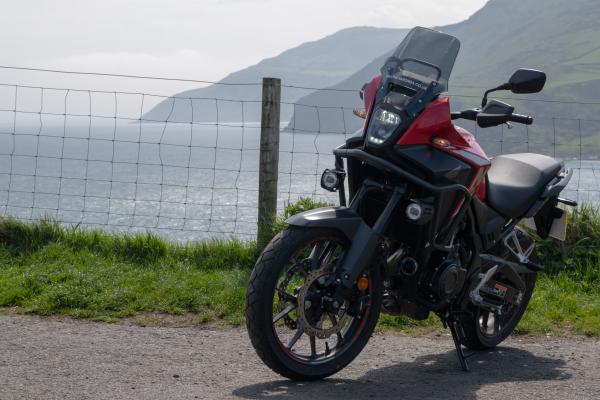 A Honda NX500 in front of some cliffs overlooking the sea