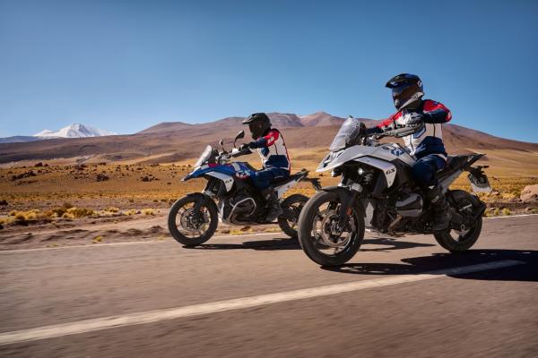 Two R 1300 GS motorcycles riding along a desert road