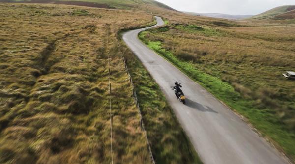  A lone motorcyclists riding along a Welsh mountain road