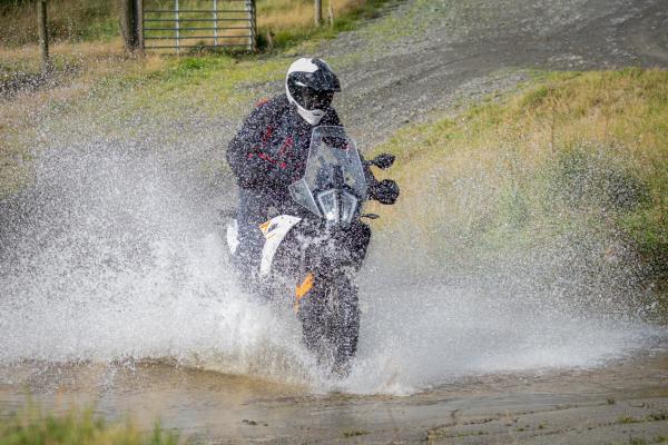 A KTM adventure motorcycle fording a river