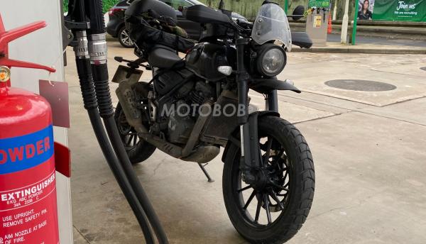 Triumph single-cylinder motorcycle at a petrol station