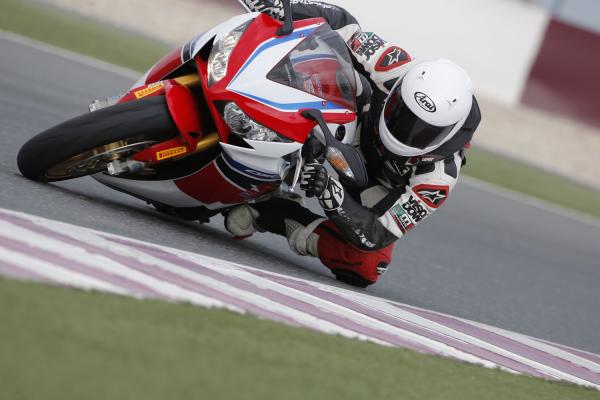 A red, white and blue 2014 Fireblade CBR1000RR-SP being ridden around a racetrack