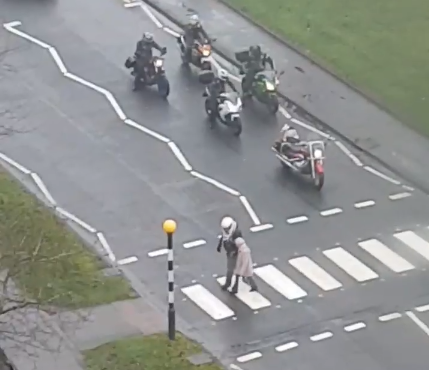 Biker helps old lady across road