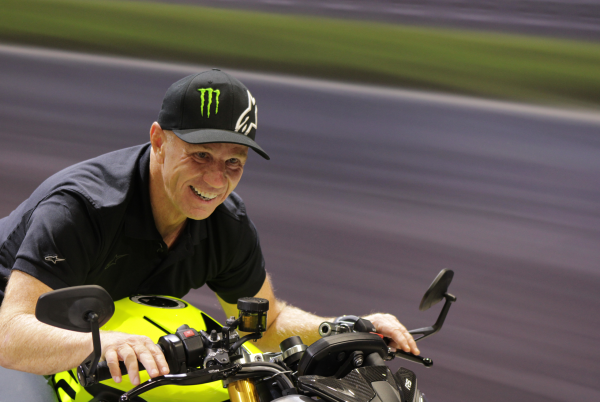 Randy Mamola sitting on Triumph Street Triple 765 Moto2 Edition at Motorcycle Live 2022.