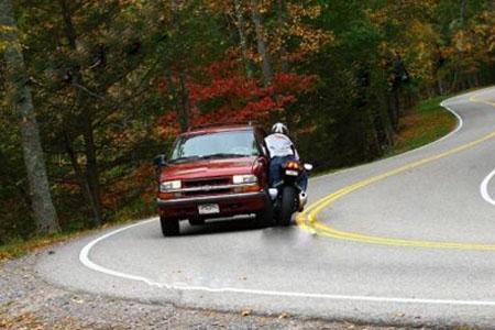 Biker runs wide and strikes car - photo sequence