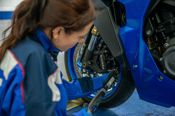 Mechanic servicing Suzuki motorcycle. - Suzuki