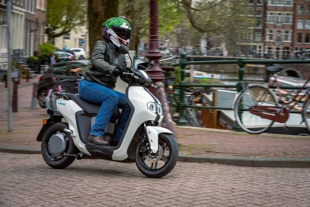 Yamaha NEO's riding through an urban area. Ride wearing blue riding jeans and black, leather riding jacket and Joker Ruroc ATLAS 4.0 helmet.