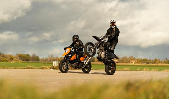 Two riders on supermotos wearing Mo'Cycle airbag vests and jeans.