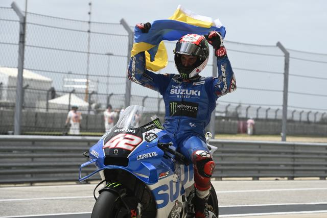 Alex Rins holds Ukrainian flag, 2022 MotoGP Grand Prix of the Americas.