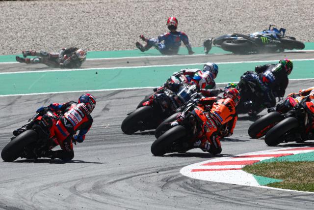 Takaaki Nakagami and Alex Rins slide through Barcelona run-off as MotoGP field files through turn one. - Gold and Goose