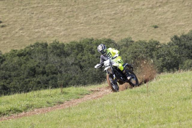 A motorcycle kicking up dirt while being ridden off-road