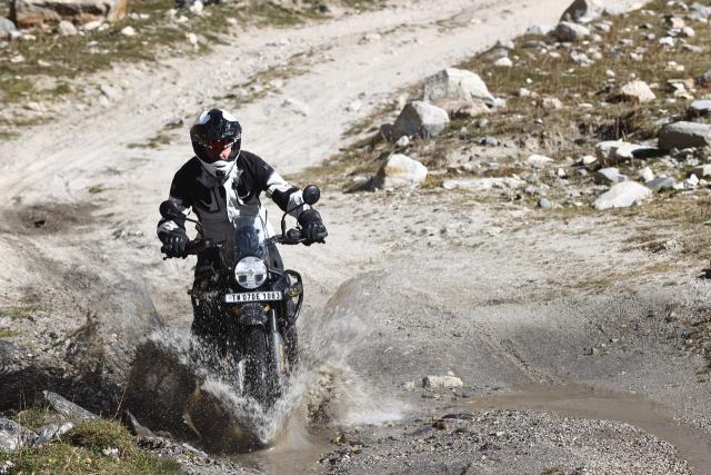 A motorcycle being ridden through a water splash