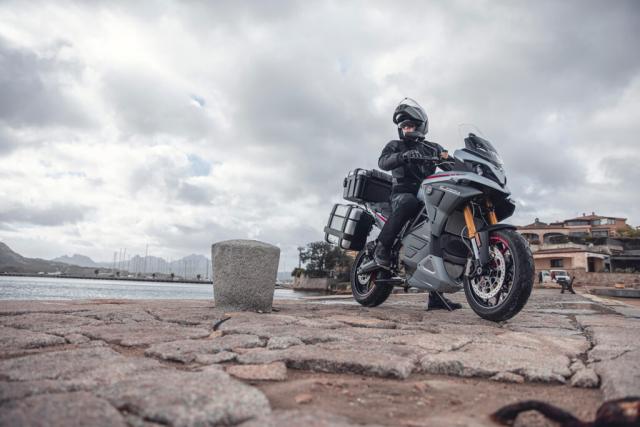 Experia electric sports touring motorcycle parked on some rocks