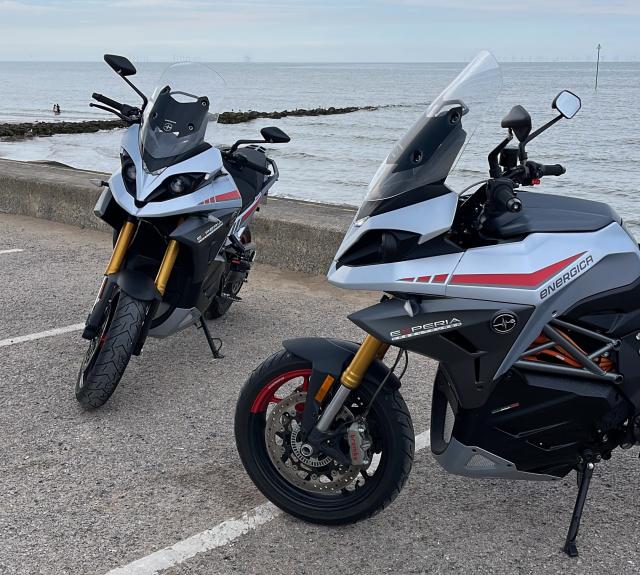 two electric motorcycles parked on the coast