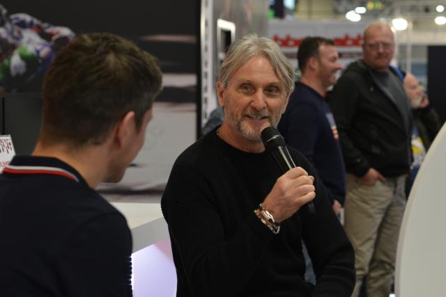 Carl Fogarty at Motorcycle Live holding a microphone