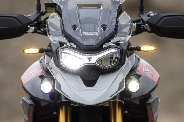 The headlights of a Triumph adventure motorcycle