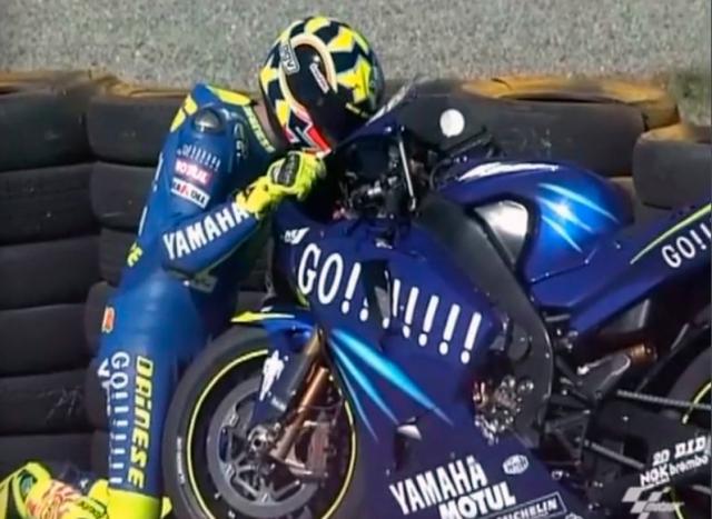 Valentino Rossi hugs Yamaha M1 after 2004 MotoGP South African Grand Prix. - Gold and Goose