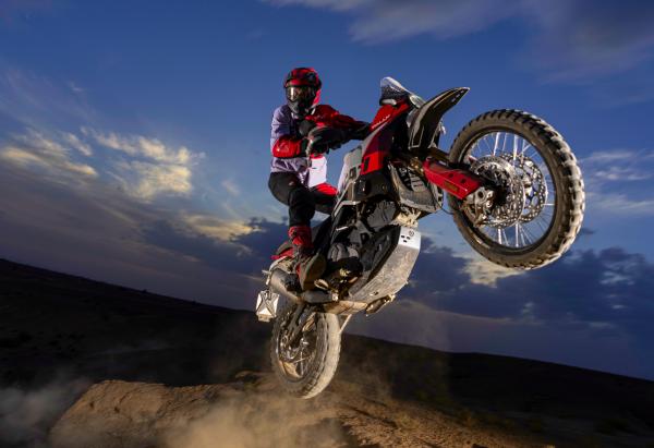 A motorcycle jumping over a rock in the desert