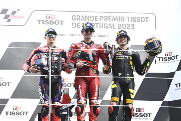 Francesco Bagnaia, Maverick Vinales, Marco Bezzecchi, on 2023 MotoGP Portuguese Grand Prix podium. - Gold and Goose