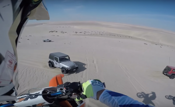 Dirt bike jumps 100ft before landing on Jeep in desert