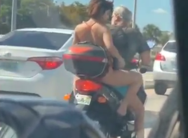 Woman shaves legs on moped