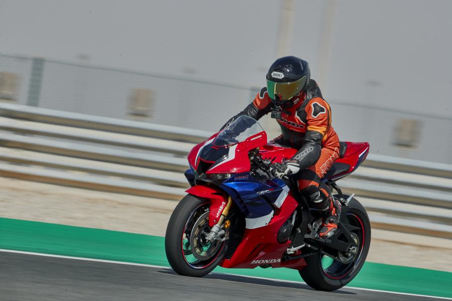 A red, blue and white 2020 Honda CBR1000RR-R SP being ridden around a racetrack
