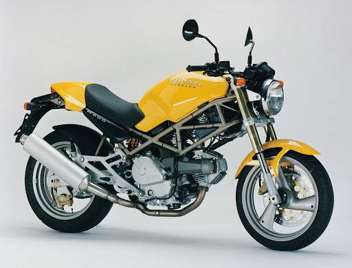 A yellow and black Ducati Monster M600 in a studio